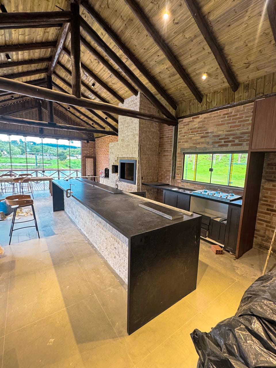 Área gourmet rústica com churrasqueira em pedra — Ceccon Construtora, Campina Grande do Sul, PR