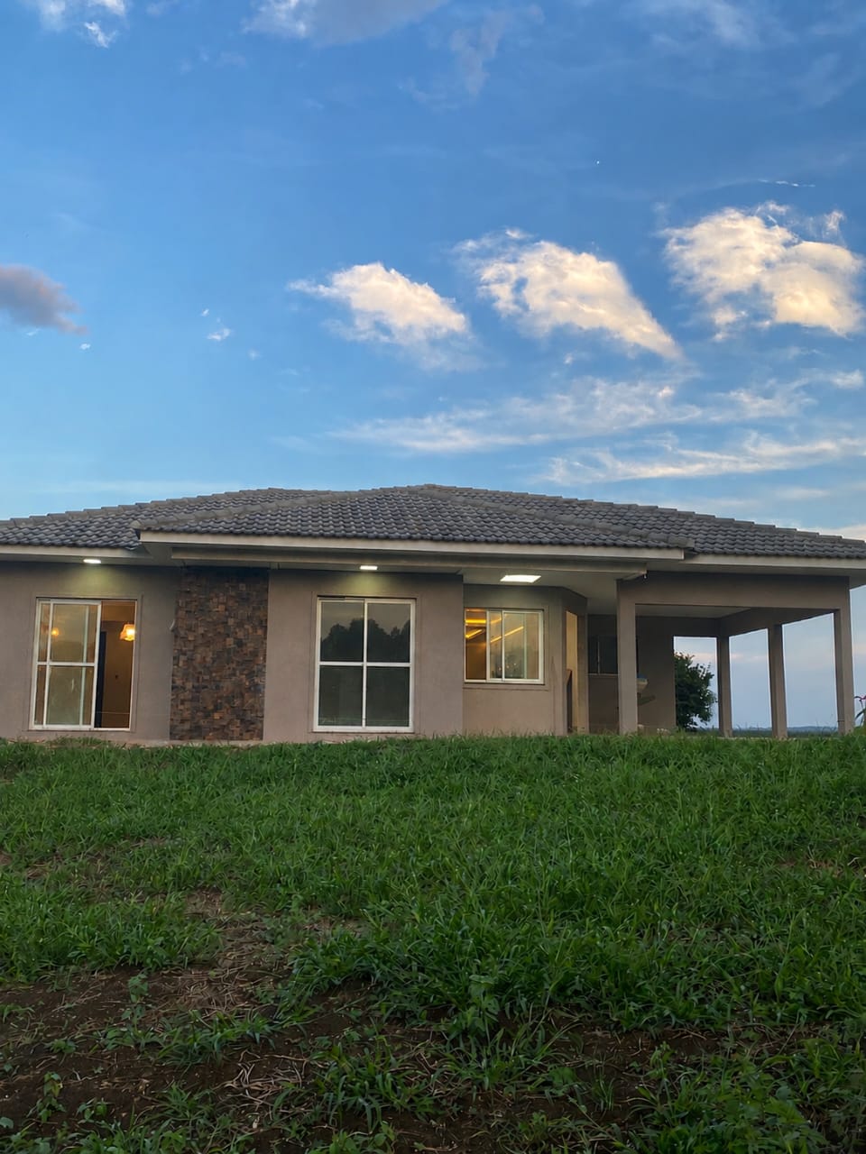 Casa com iluminação noturna e pedra natural construída pela Ceccon — Campina Grande do Sul, PR